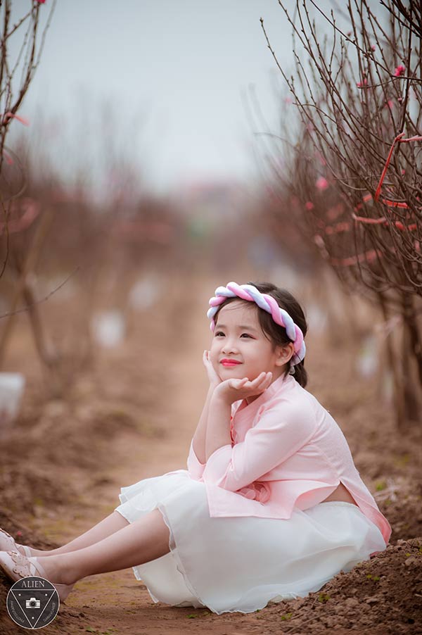 Bé gái 6 tuổi diện áo dài bên vườn đào - 7