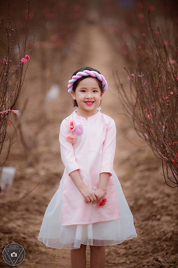 Bé gái 6 tuổi diện áo dài bên vườn đào - 6